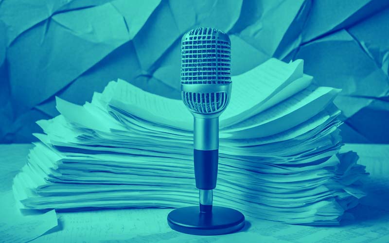 A microphone sitting front a stack of documents